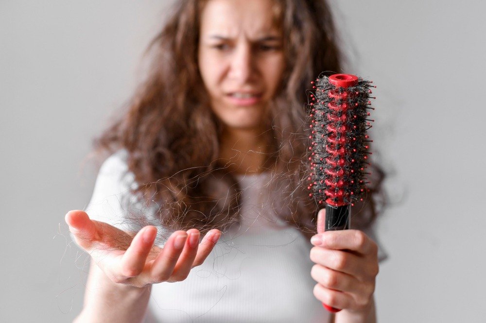 1. A woman holds a comb above her head, showcasing a playful and confident expression in a bright, cheerful setting.