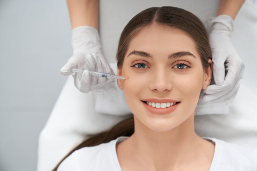 Smiling woman receiving Glutathione injection for skin rejuvenation and brightening treatment.